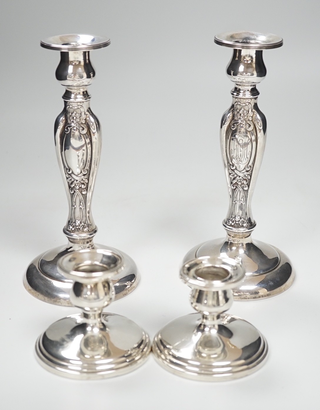 A pair of ornate sterling mounted candlesticks, 20.3cm, weighted and a pair of silver mounted dwarf candlesticks, 68mm, weighted.